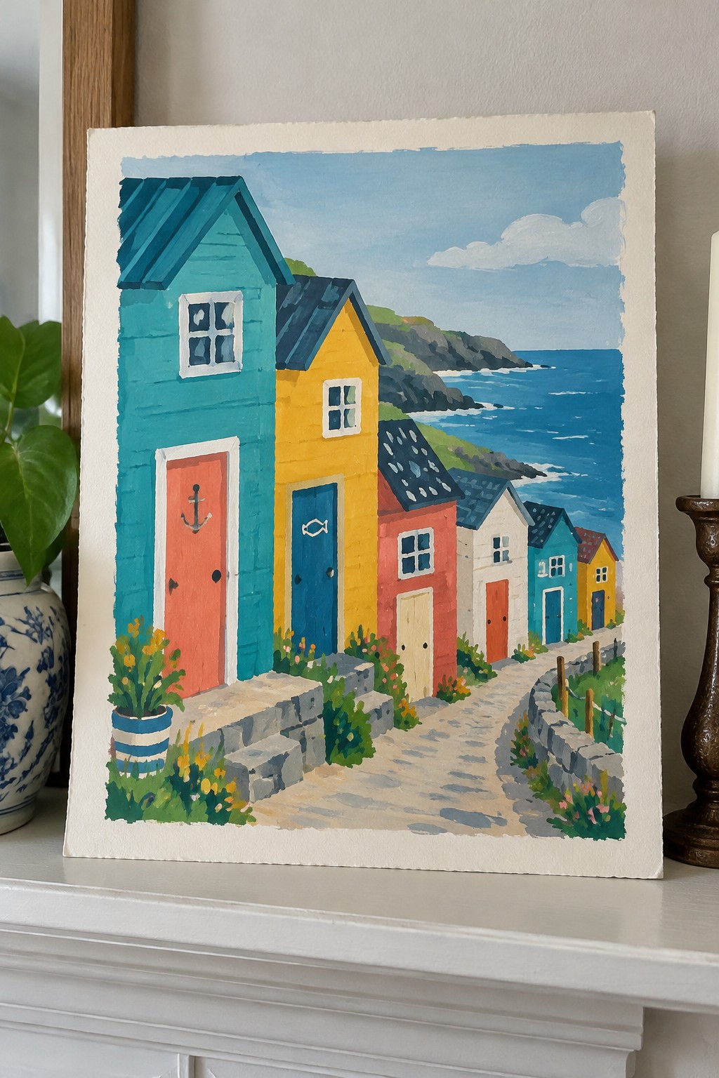 Colorful seaside houses in teal, yellow, and red line a stone path by the ocean.