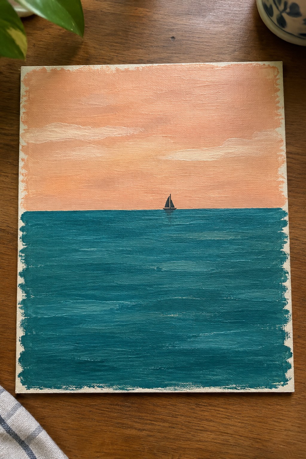 Canvas painting of tiny sailboat on teal sea under peach-orange sky