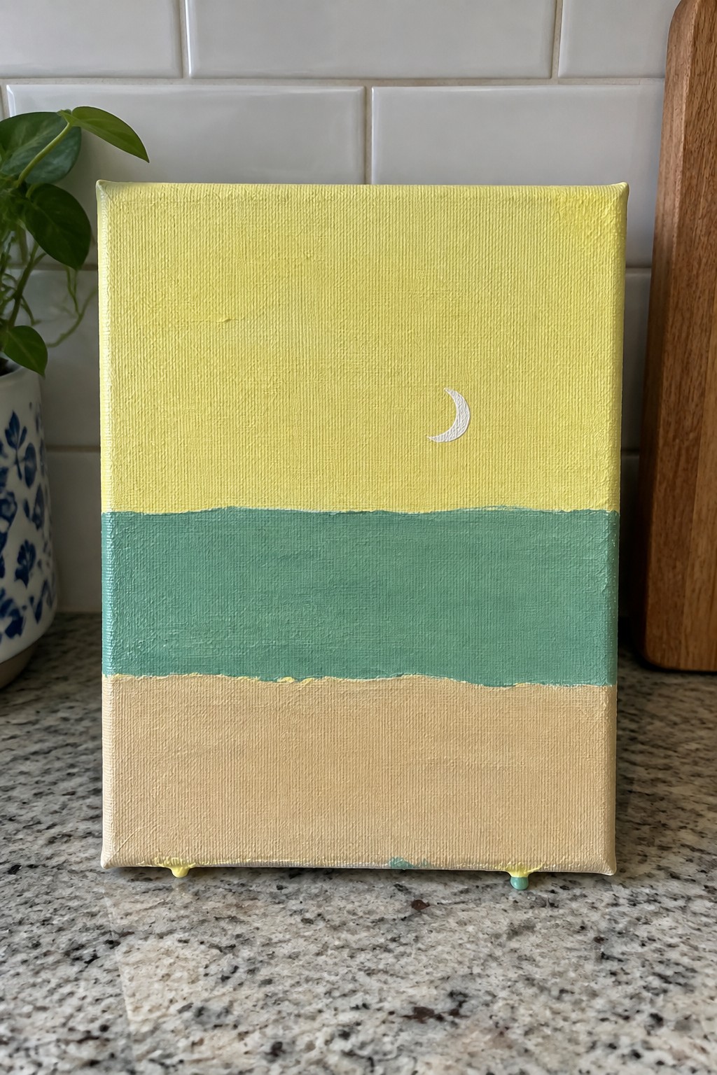 Mini canvas painting with yellow top, white crescent moon, green middle, and beige bottom