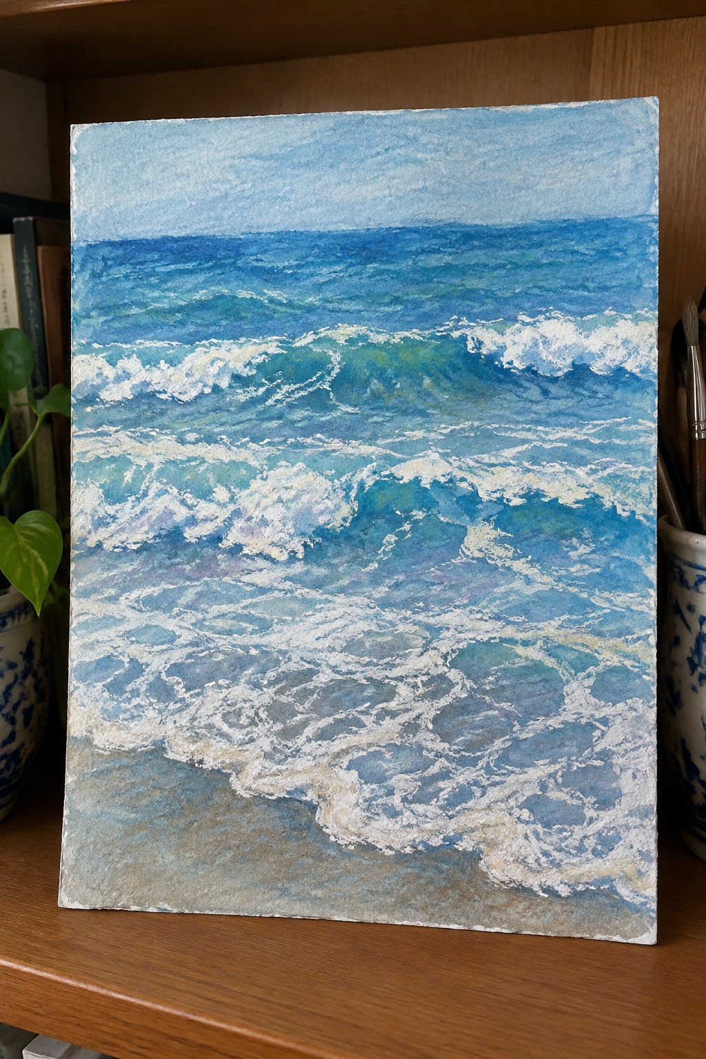 Watercolor seascape of blue ocean waves with white foam nearing sandy shore