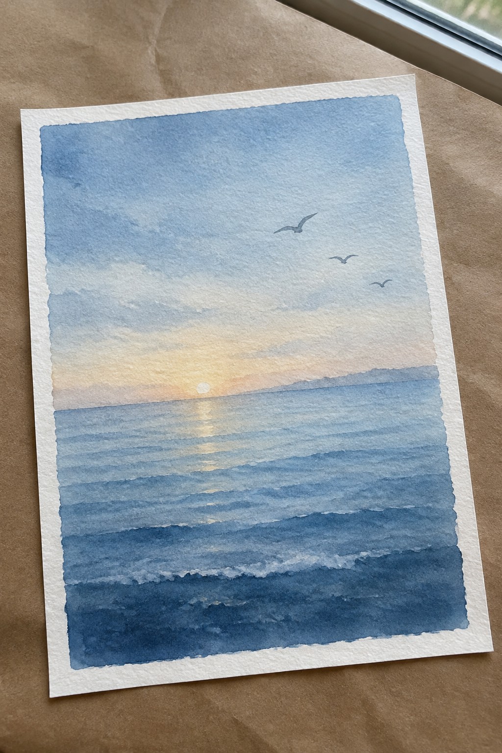 Watercolor seascape of sunset over blue ocean waves with sun reflection and three birds.