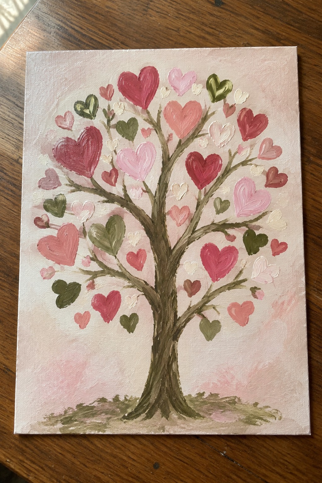 Canvas painting of tree with pink red green heart-shaped leaves on wood