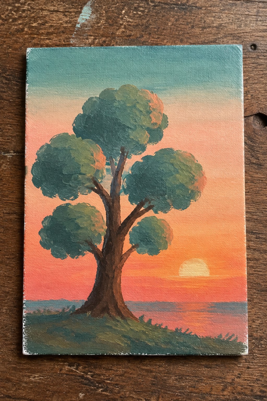 Tree with green foliage against orange-pink sunset over water on canvas