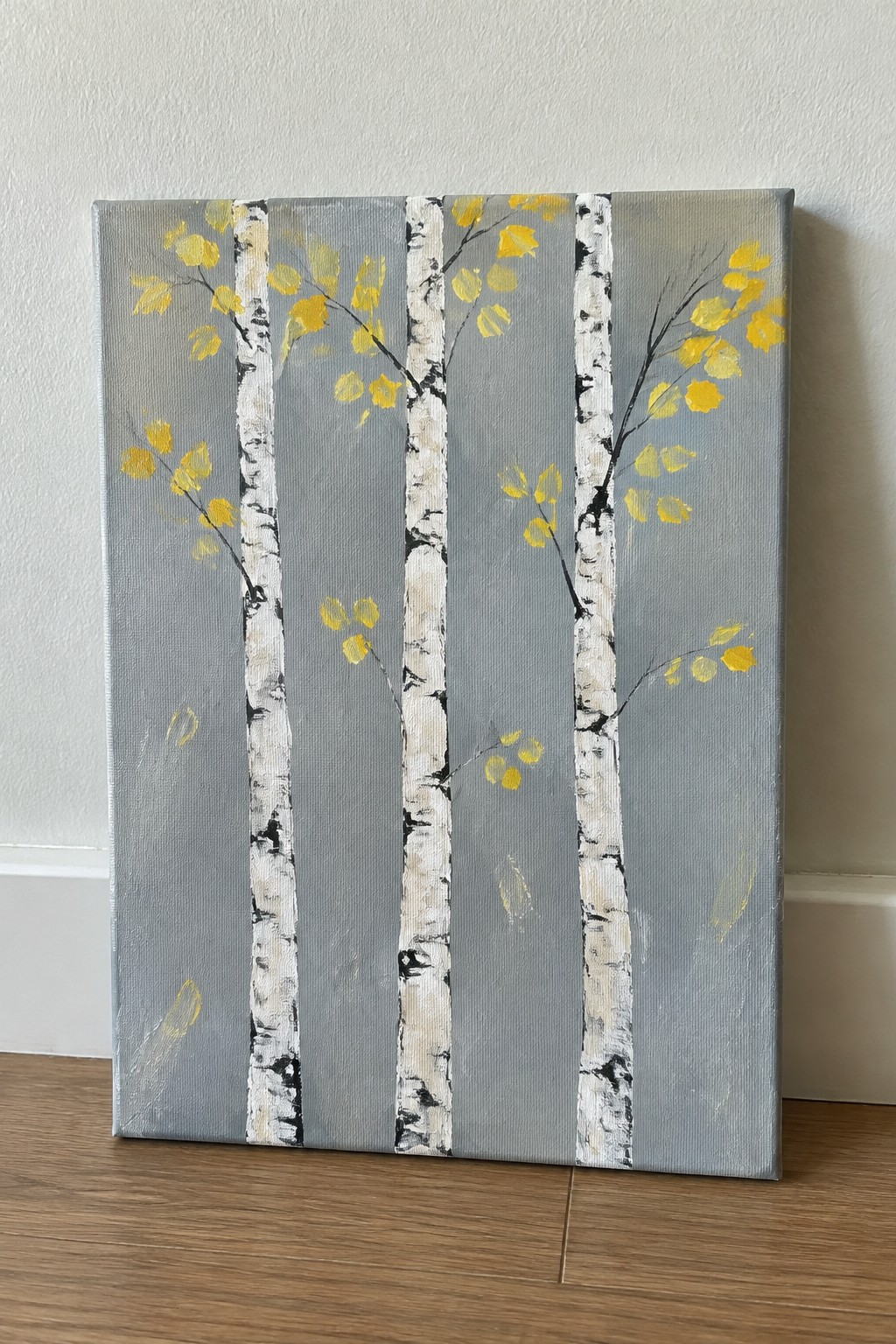 Three birch trees with white bark, black markings, and yellow leaves on gray canvas.