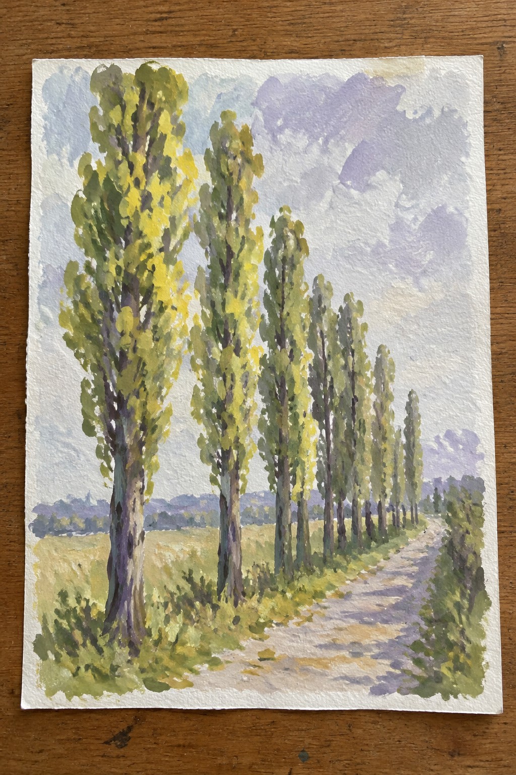 Watercolor painting of tall green trees lining a winding dirt path under a cloudy sky.
