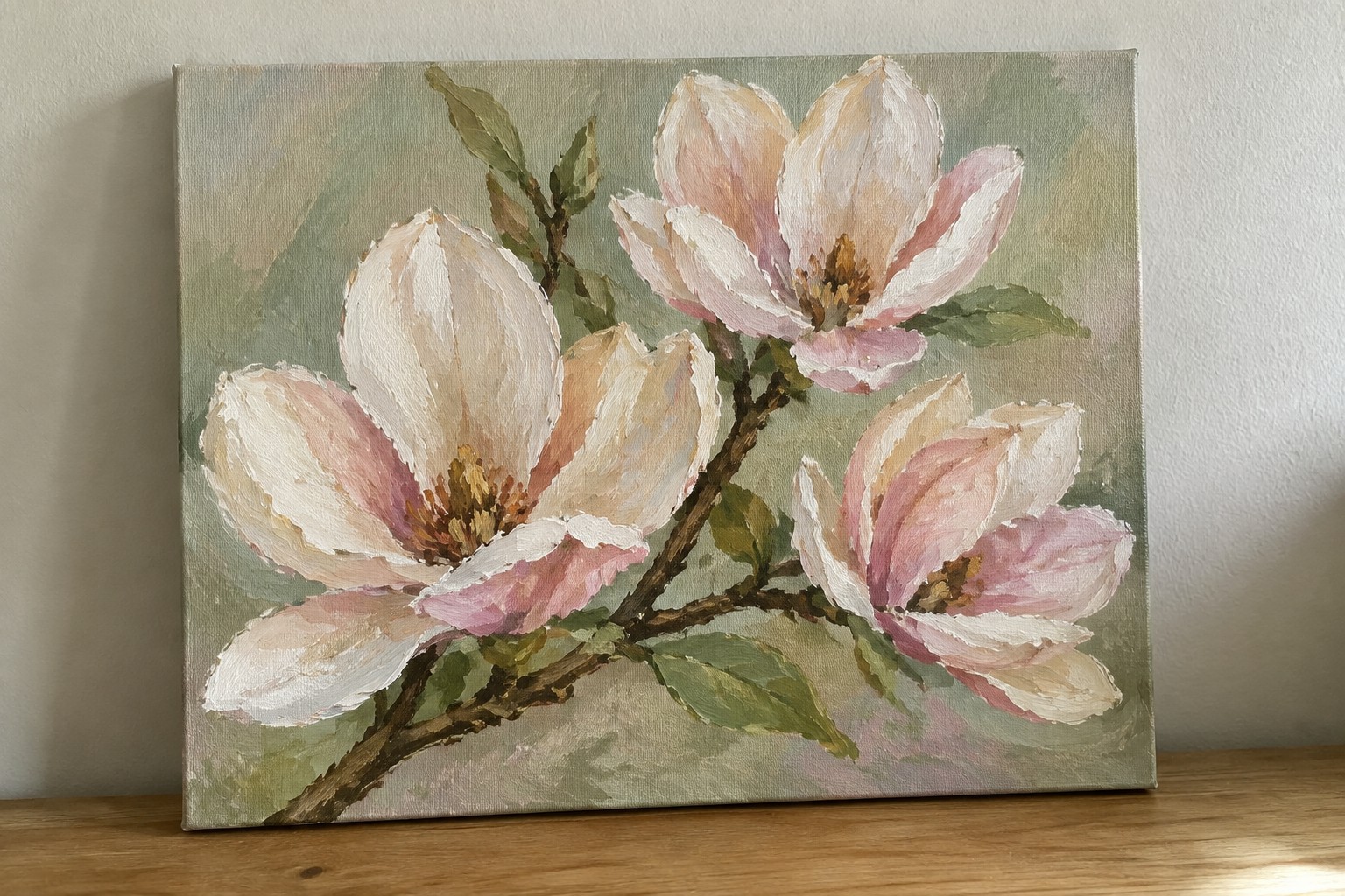 Painterly canvas of white and pink magnolia flowers with green leaves and buds.