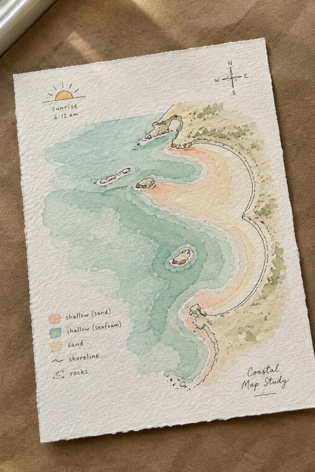 Watercolor coastal map with winding shoreline, blue-green shallows, sandy areas, compass, and sunrise.