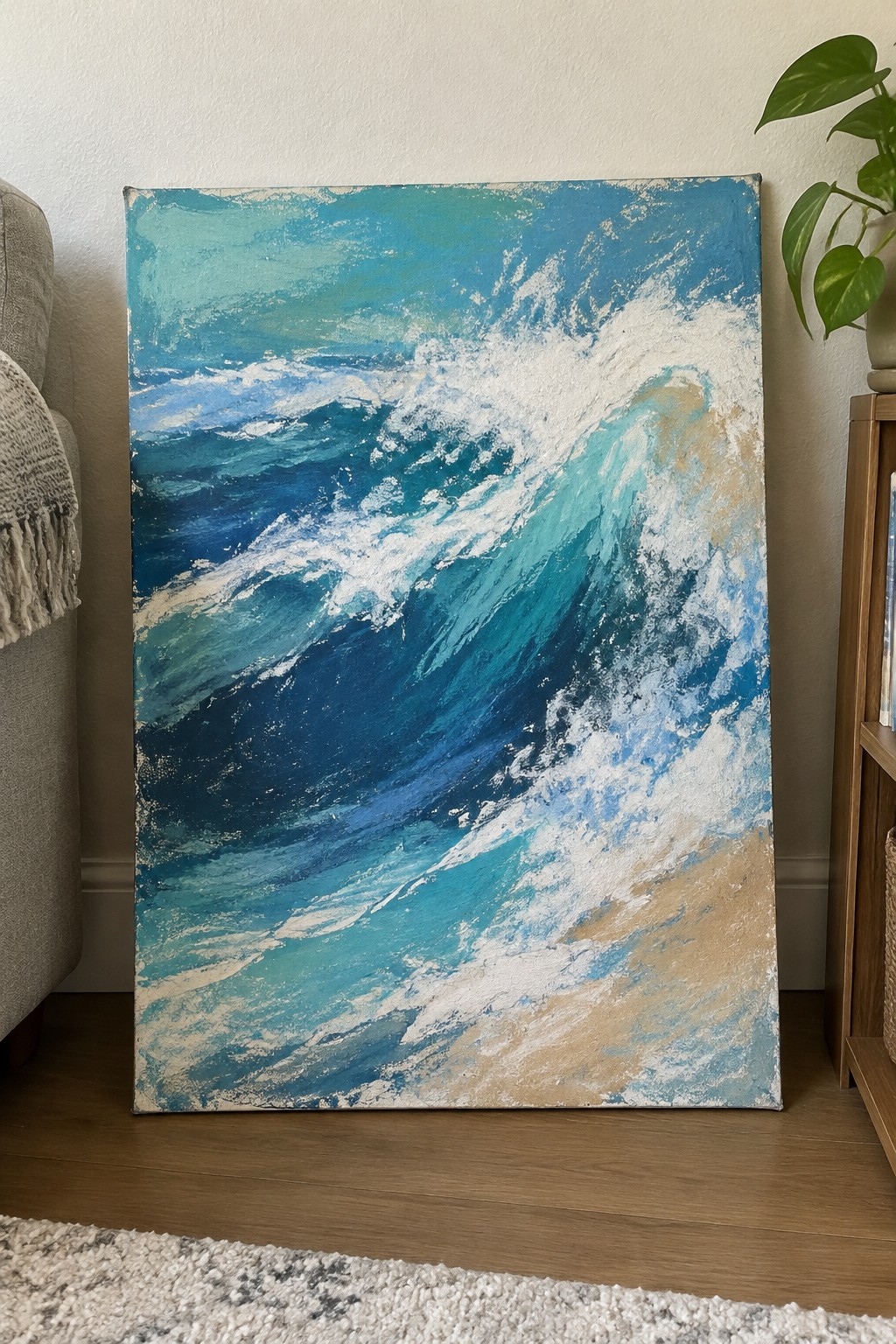 Large abstract painting of blue ocean waves with white foam in a living room