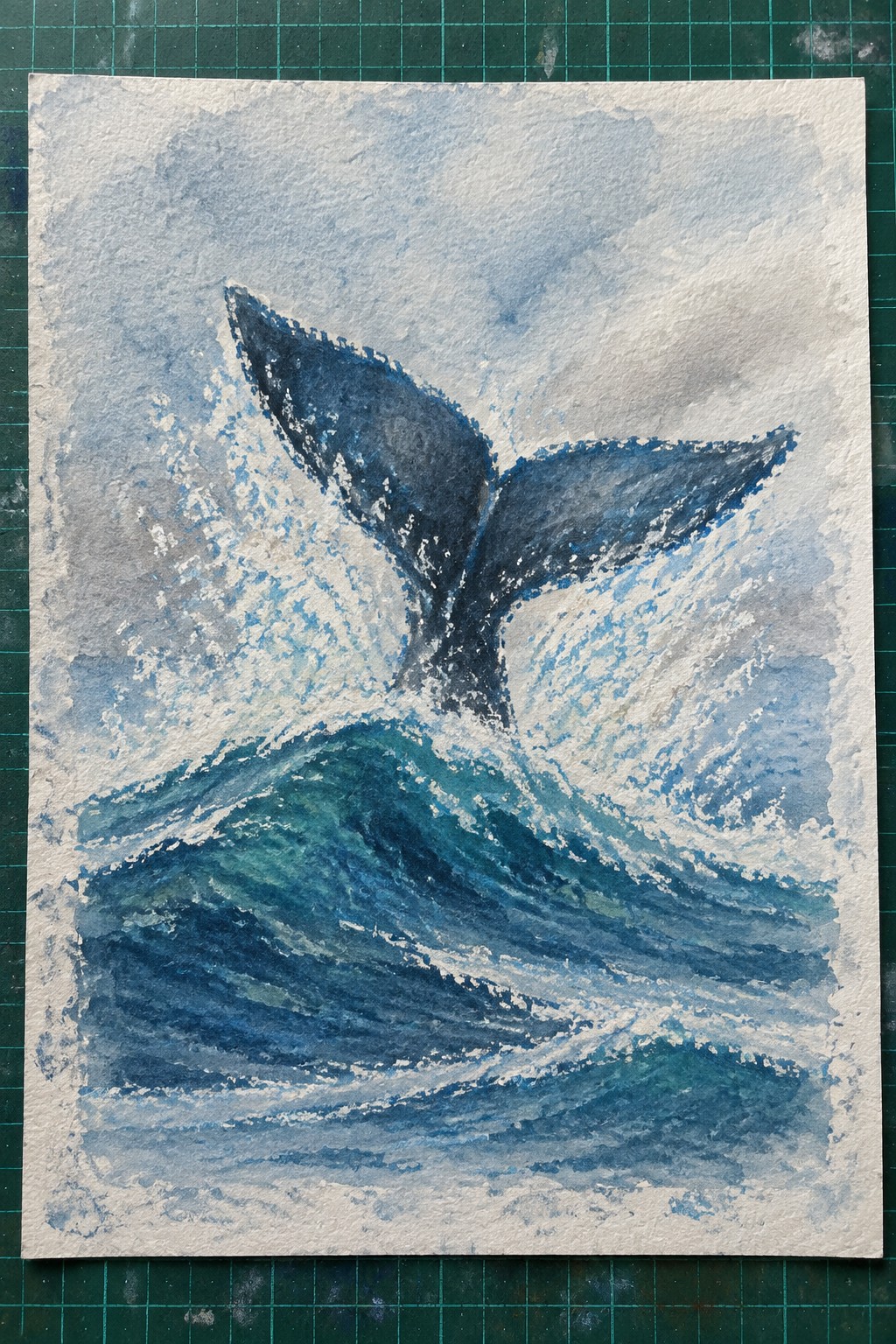 Watercolor painting of dark blue whale tail splashing amid crashing teal ocean waves with white foam