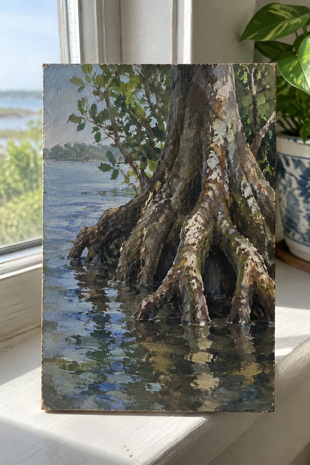 Oil painting of gnarled tree roots in blue water on windowsill beside potted plant.