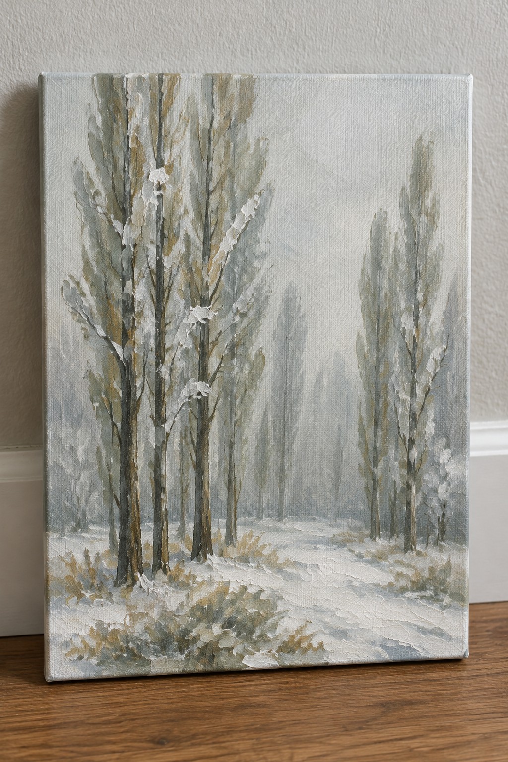 Oil painting of tall snow-dusted trees lining a misty winter path on canvas.