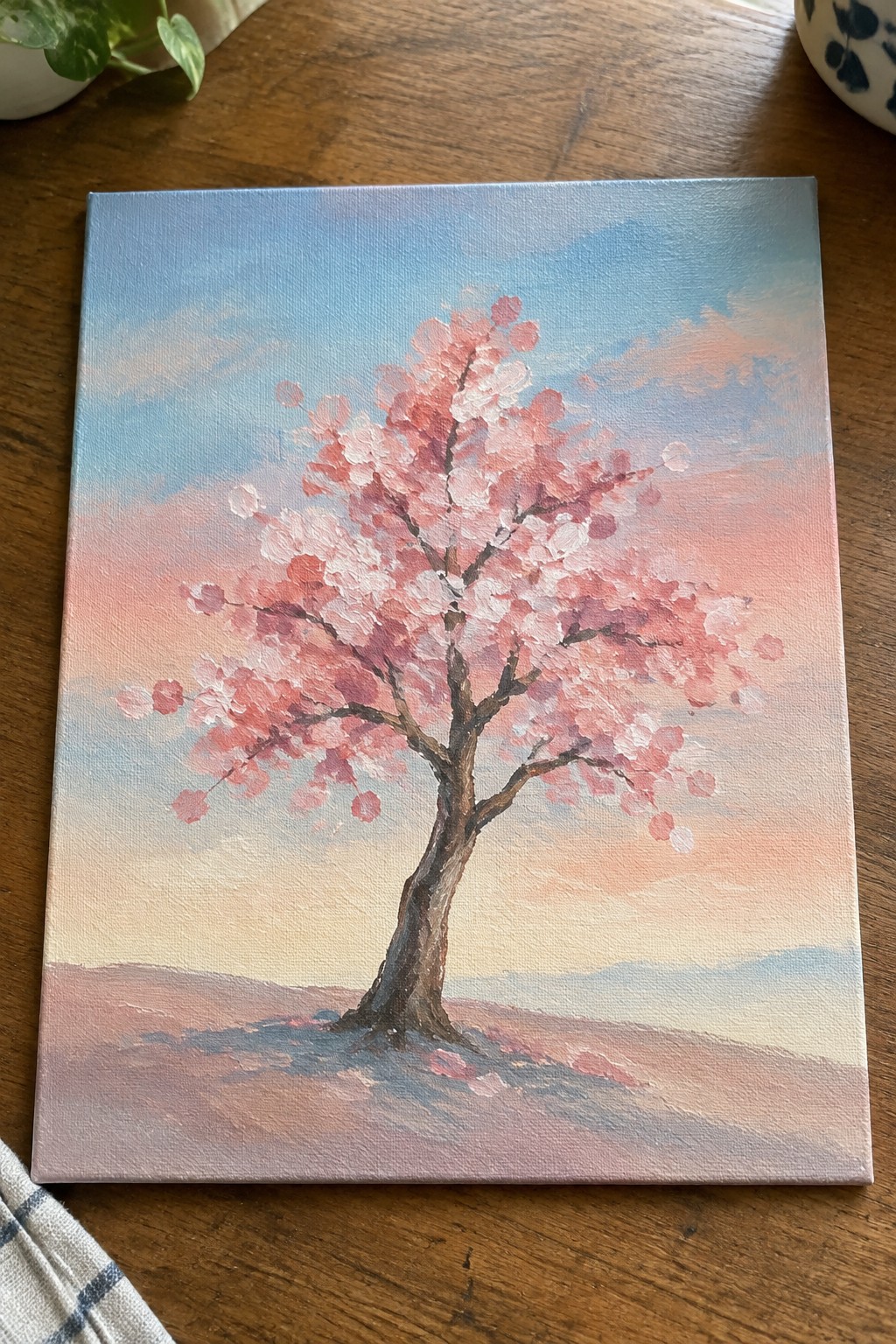 Cherry blossom tree with pink blossoms painted on canvas against pastel sky