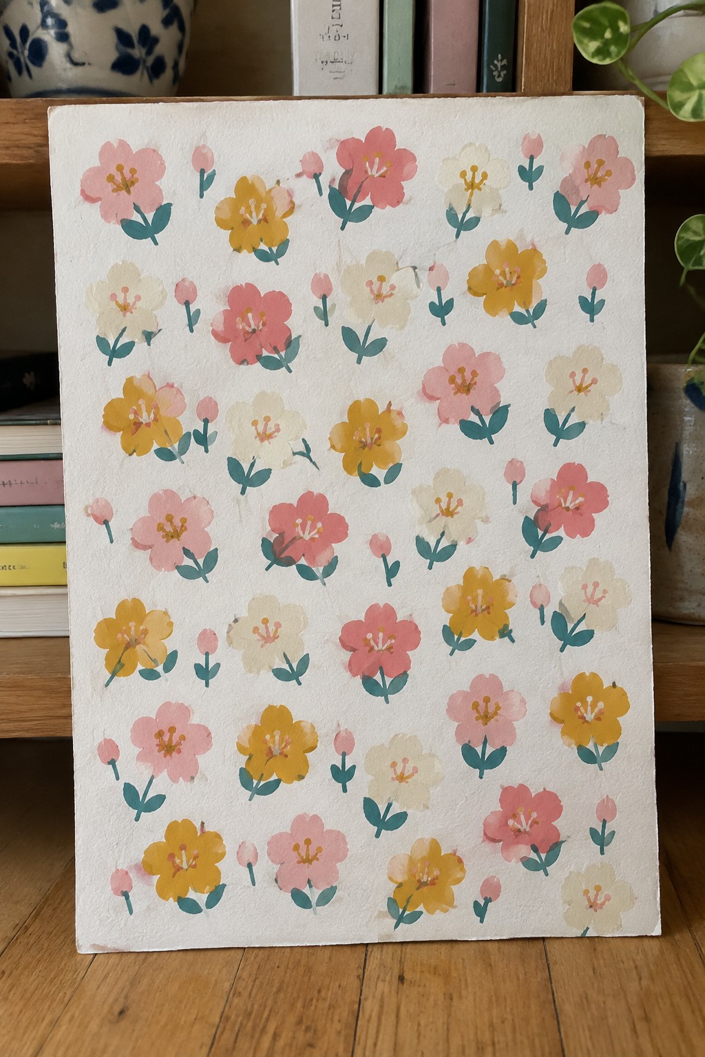 Watercolor painting of pink, yellow, and white flowers scattered on paper