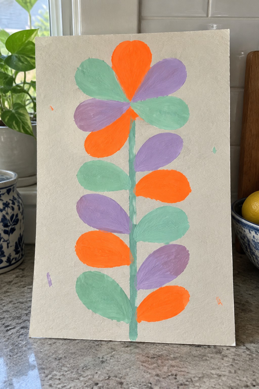 Colorful abstract flower with orange, purple, and green petals on a stem.