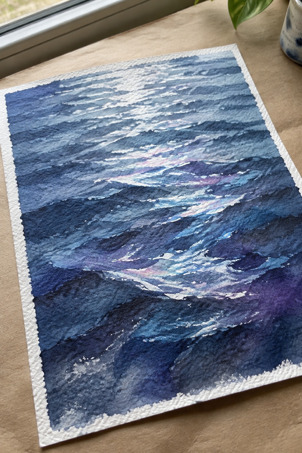 Watercolor seascape of layered blue and purple ocean waves with white foam on paper.