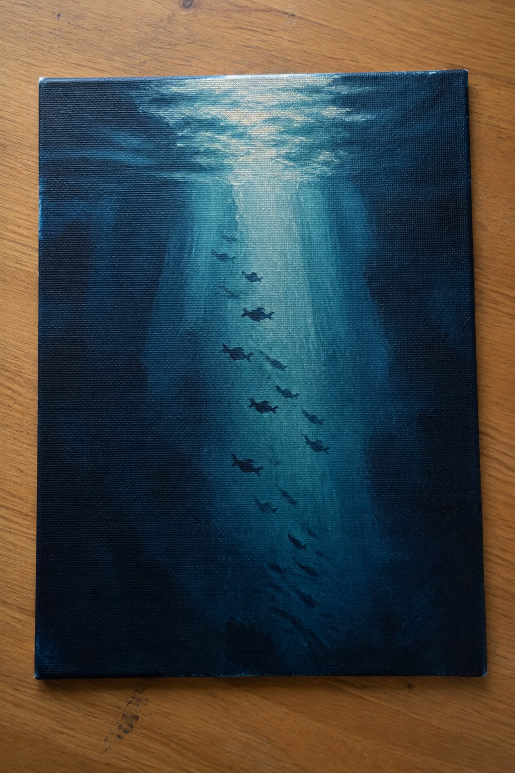 Blue underwater painting of fish swimming through sunlit ocean light rays on wood