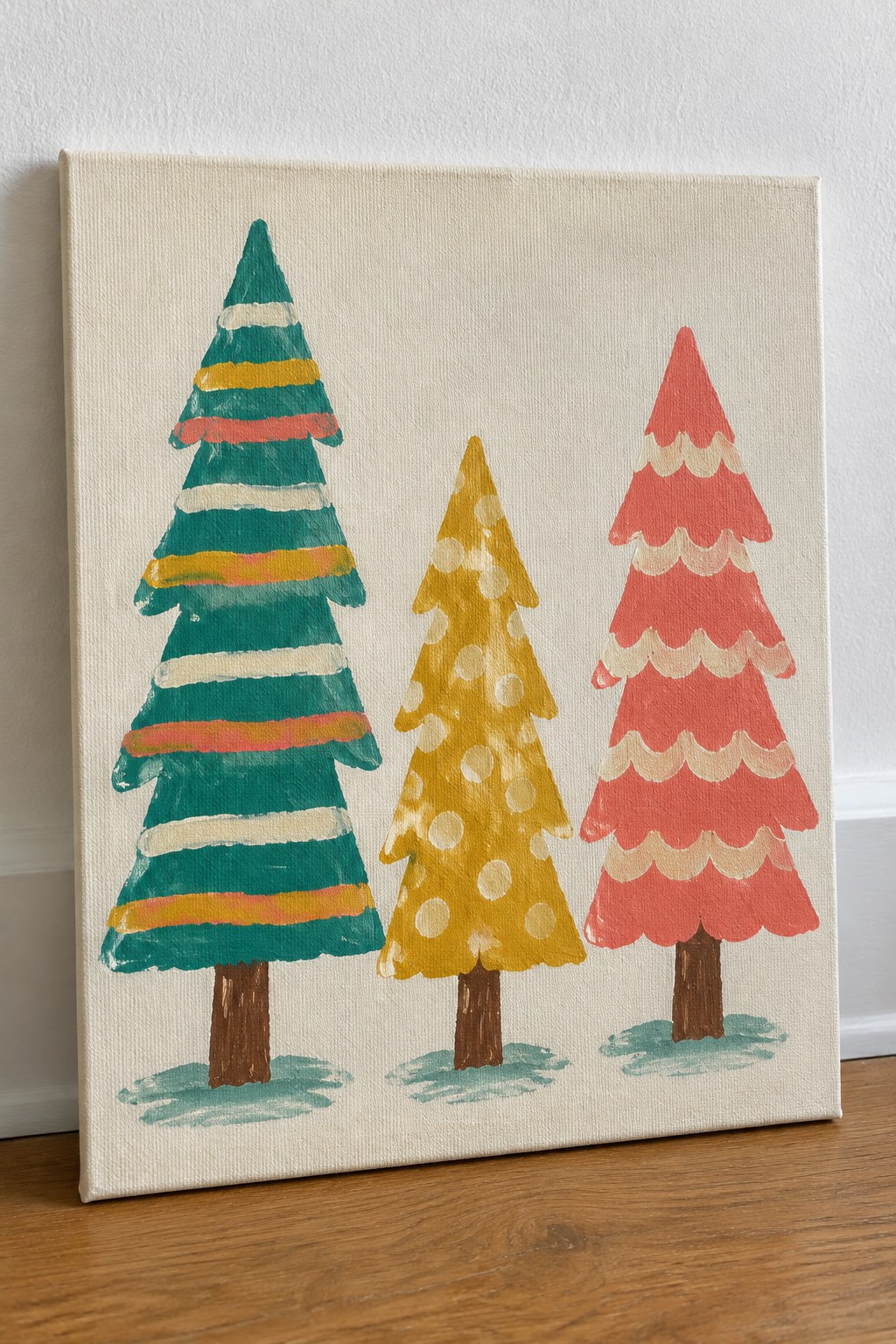 Three colorful Christmas trees painted on canvas with striped, dotted, and scalloped patterns.