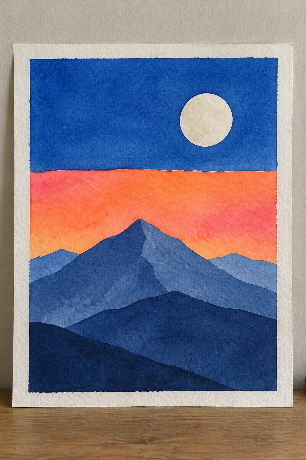 Watercolor of layered blue mountains under orange-red sunset sky with pale moon.