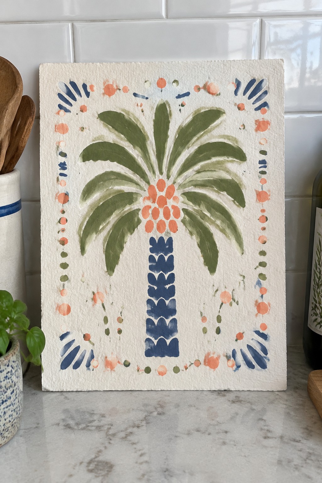 Watercolor palm tree with green fronds, blue trunk, and orange accents on white paper