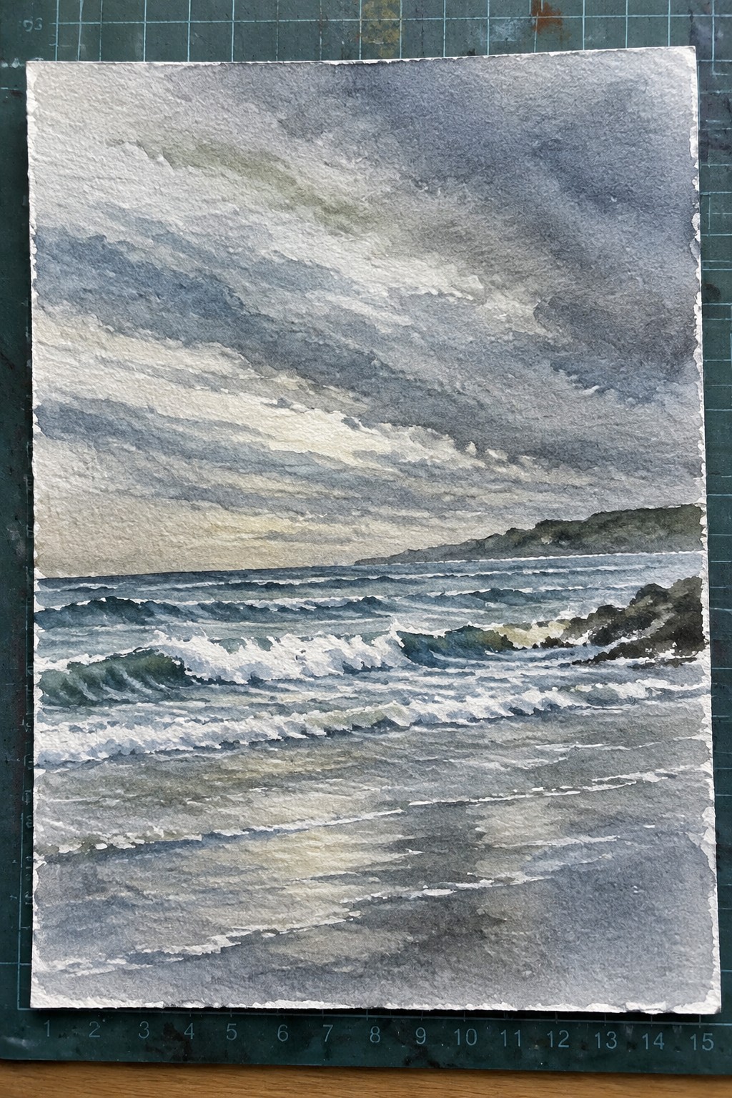 Watercolor painting of crashing waves on rocky shore under stormy gray skies