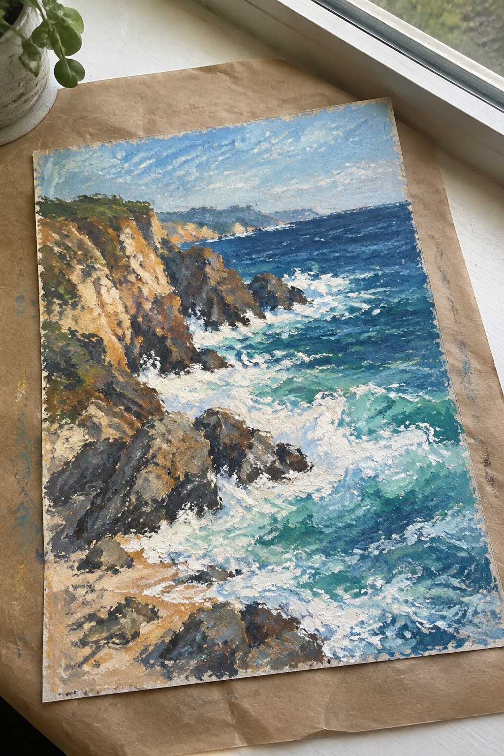 Impressionist painting of rocky cliffs and crashing blue-green ocean waves on brown paper
