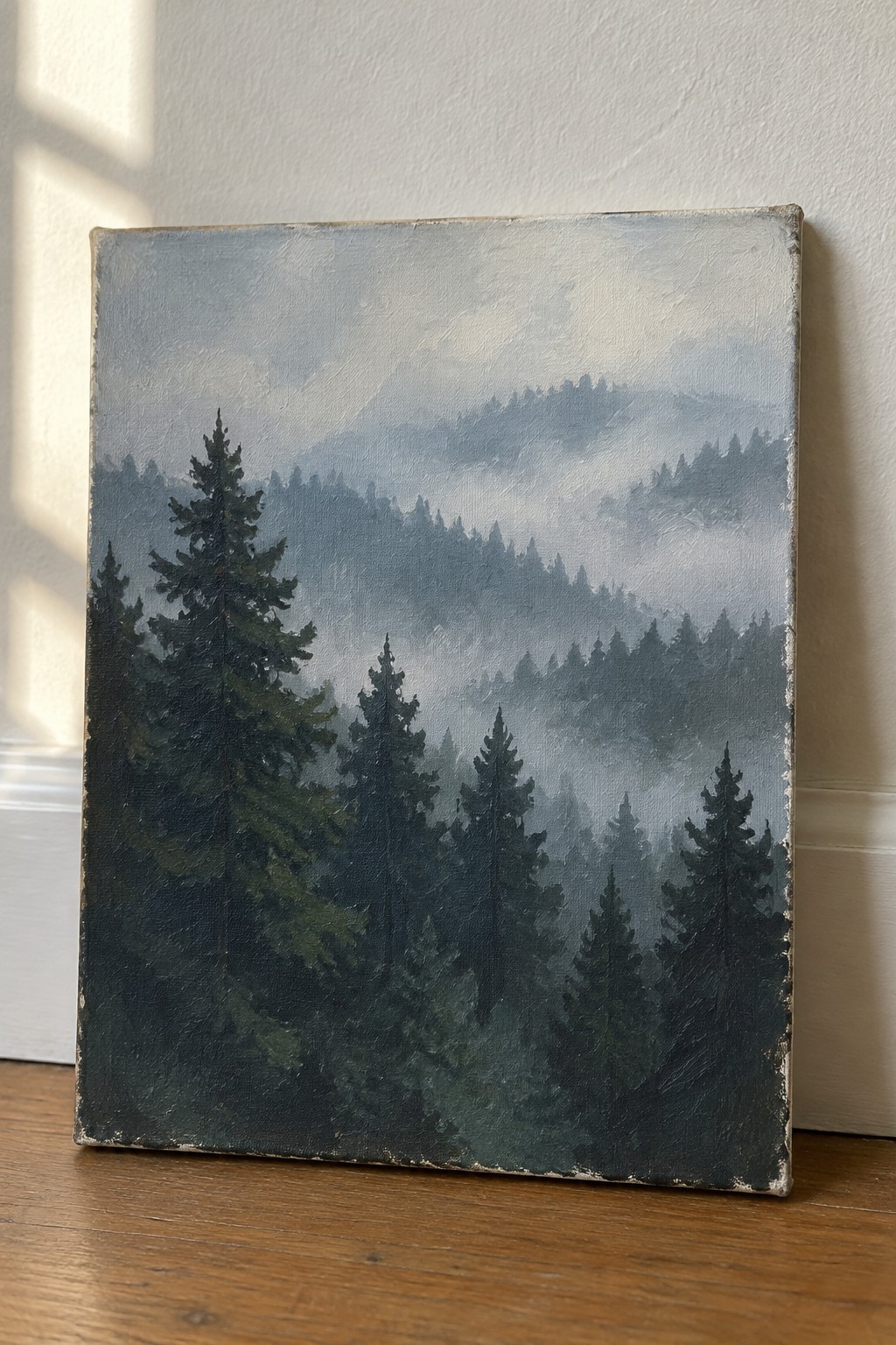 Oil painting of misty pine forest on canvas against white wall on wood floor