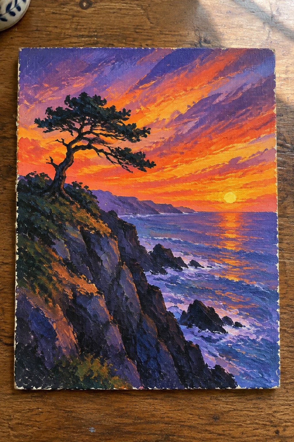 Vivid painting of windswept pine tree on cliffs at fiery orange-purple ocean sunset