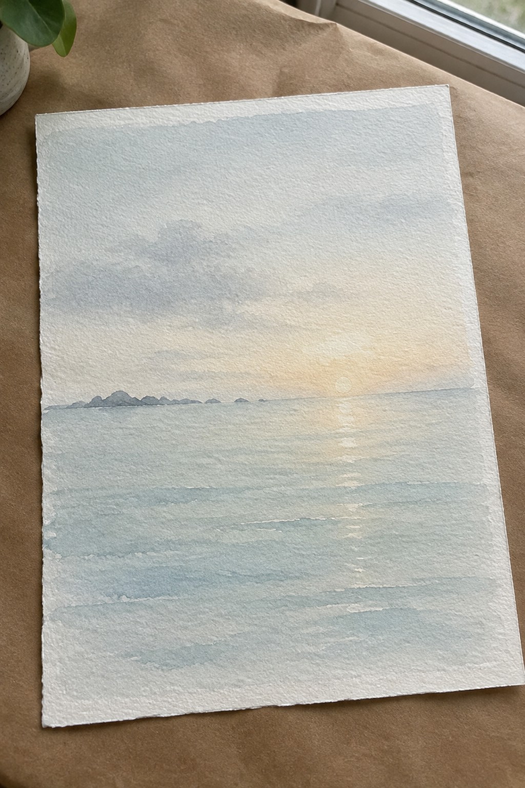 Watercolor seascape of calm sea at sunset with sun reflection and distant islands