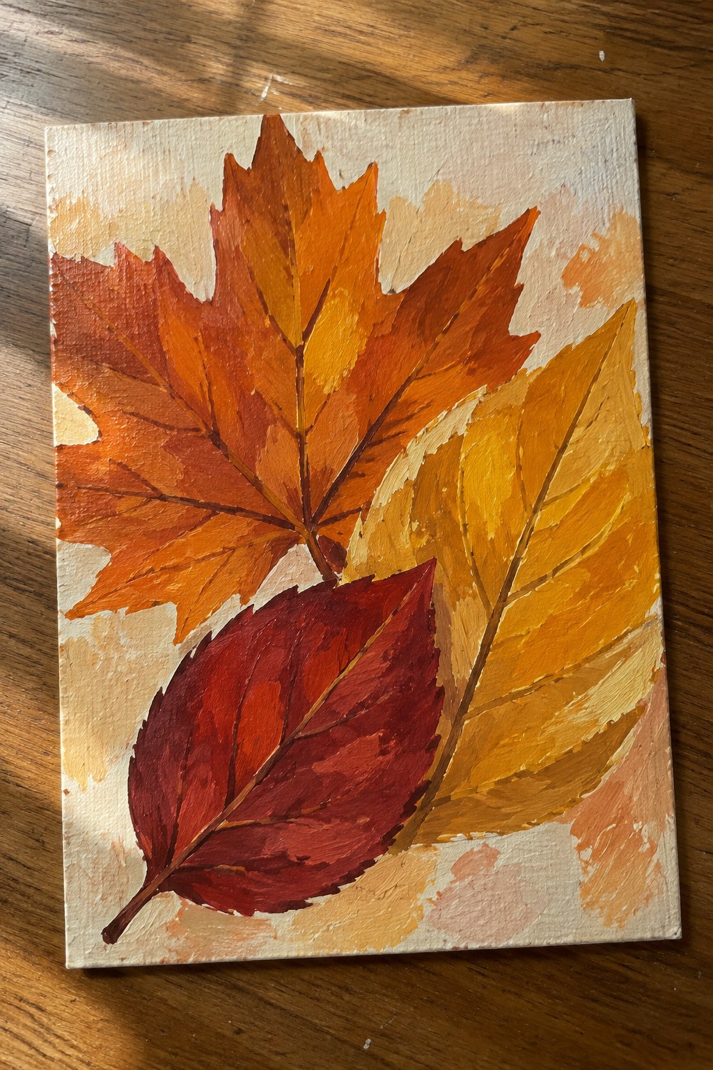 Vibrant painting of overlapping red, orange, and yellow fall leaves on canvas.