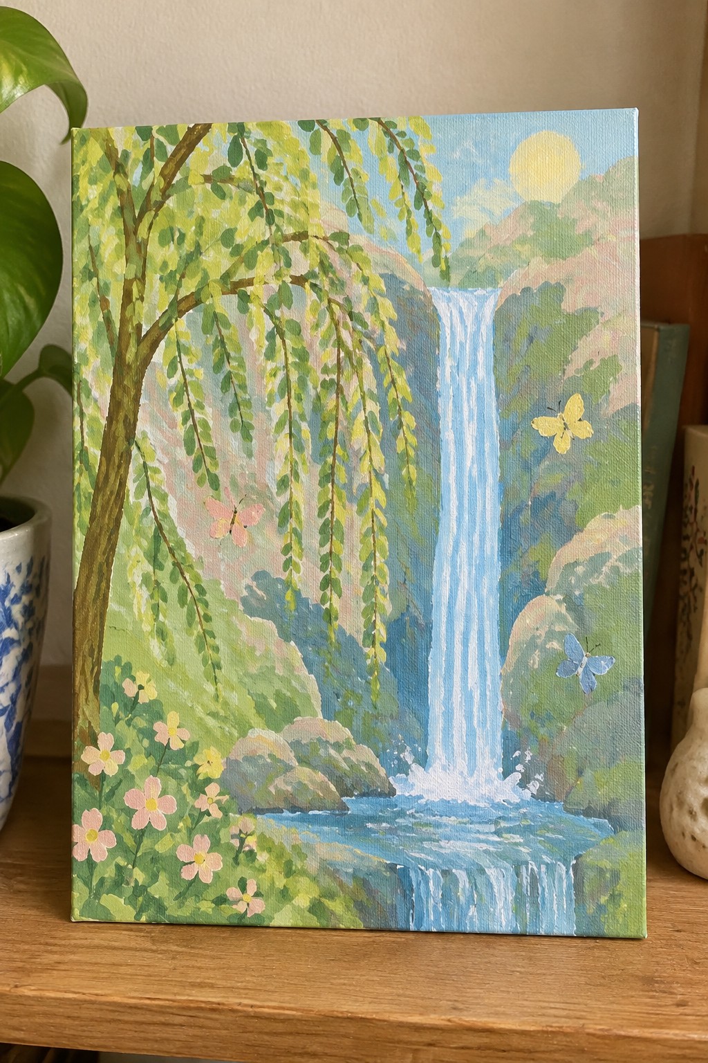 Colorful painting of a waterfall with willow tree, pink flowers, and butterflies.