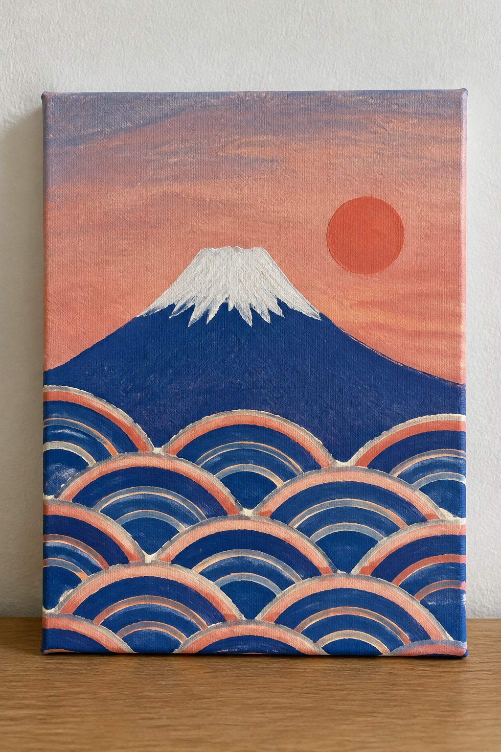 Stylized Mount Fuji painting with white peak, red sun, and blue waves