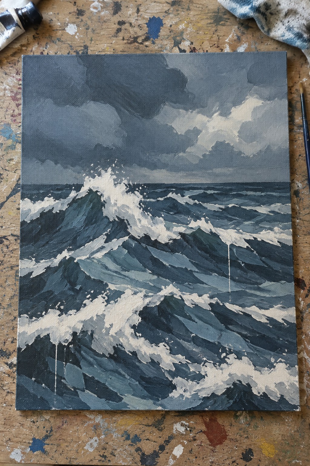 Stormy seascape painting of crashing waves with white foam on paint-splattered wood