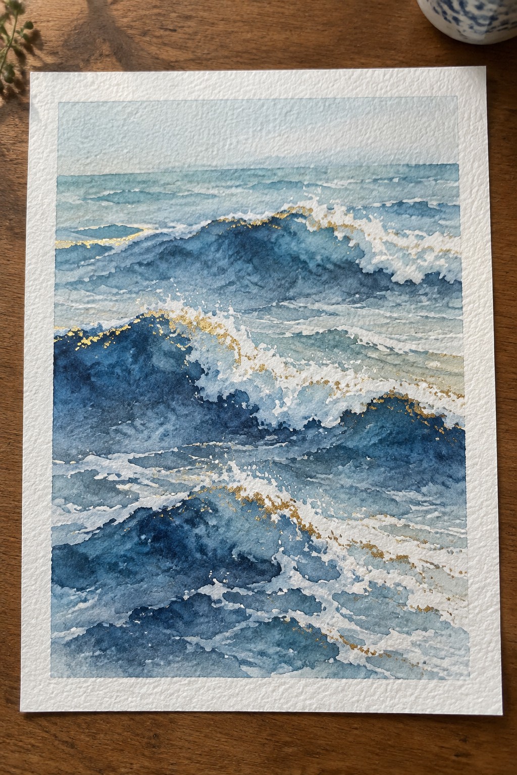 Watercolor seascape of turbulent blue ocean waves with white foam and gold accents.