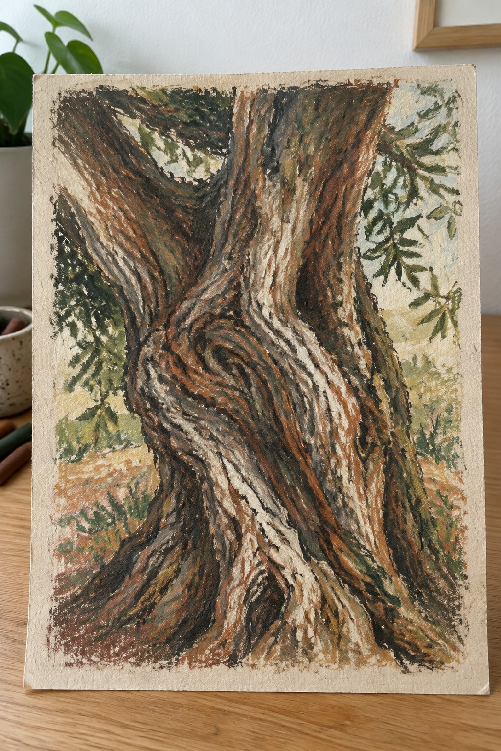 Pastel drawing of a gnarled tree trunk with swirling brown bark and green foliage.