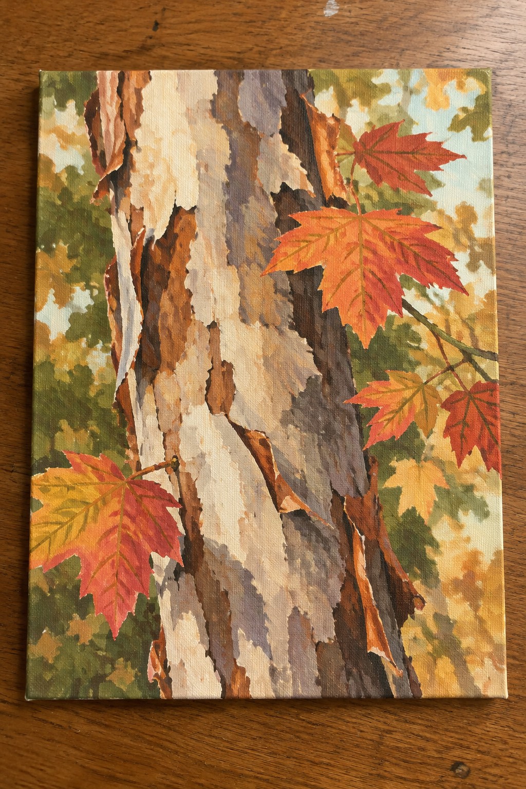 Birch tree trunk with peeling bark and red-orange maple leaves in autumn
