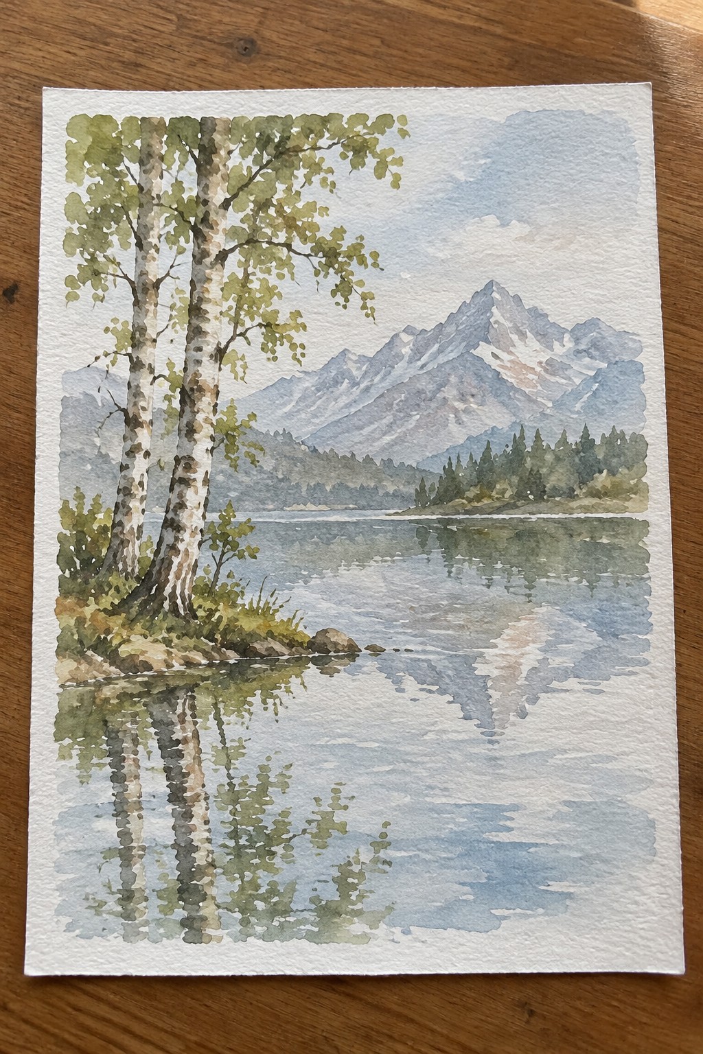 Watercolor of birch trees beside a calm mountain lake with snow-capped peaks reflected.