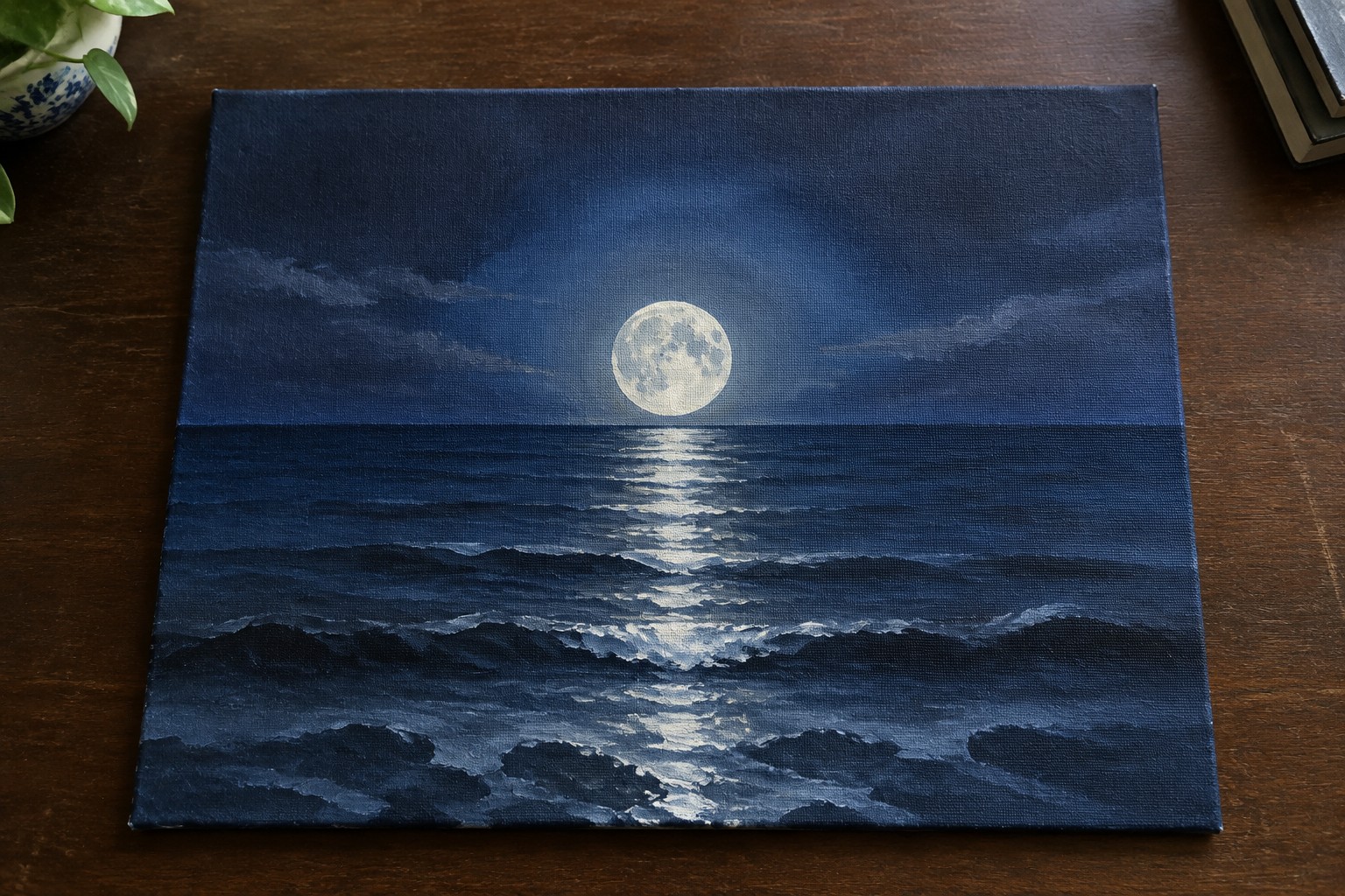 Painting of full moon over dark blue ocean with glowing wave reflections at night.