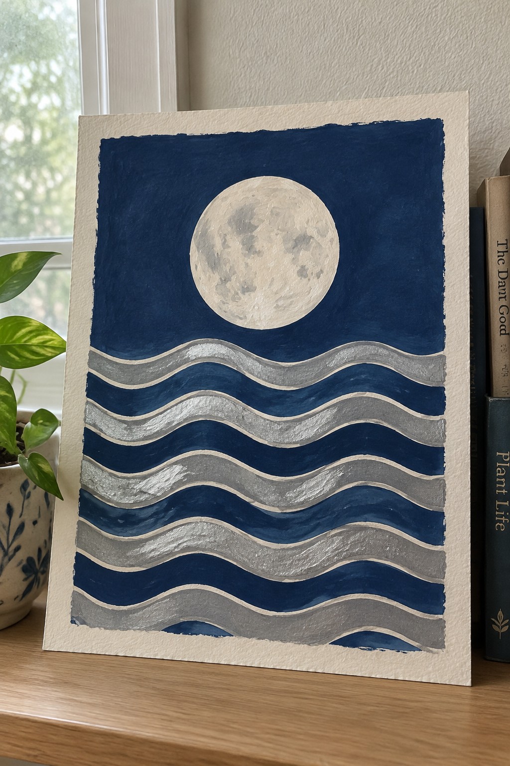 Moon painting with layered blue and silver wavy lines on paper
