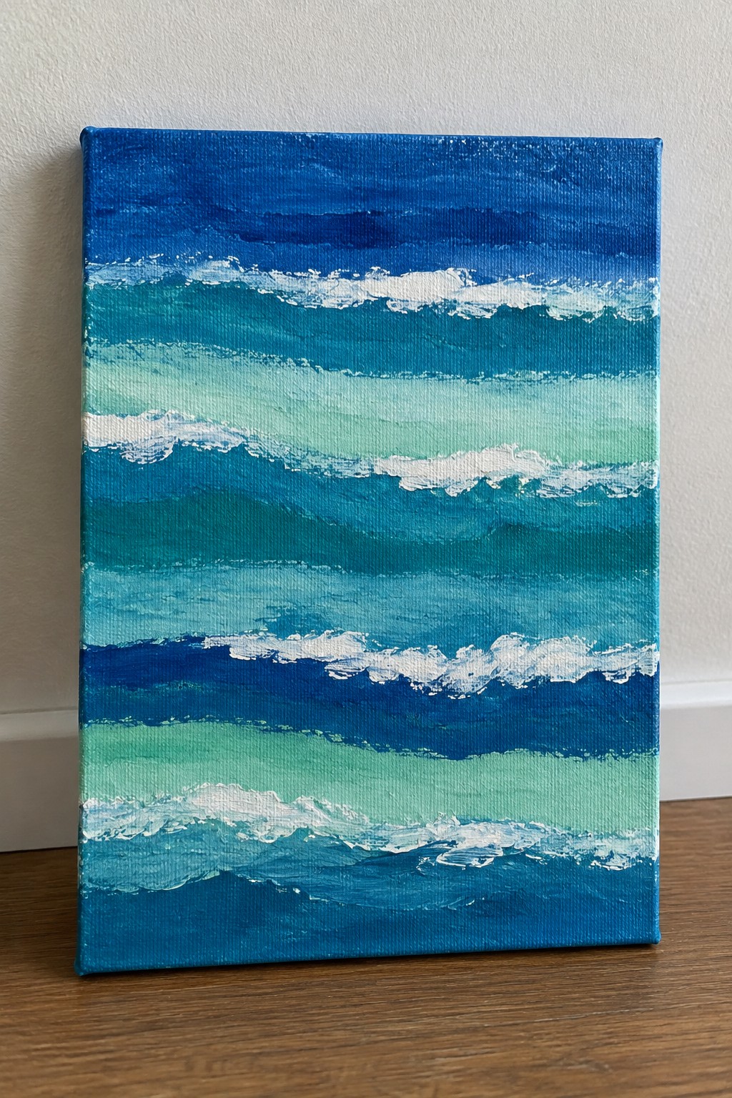 Abstract canvas painting of layered blue-green ocean waves with white foam crests