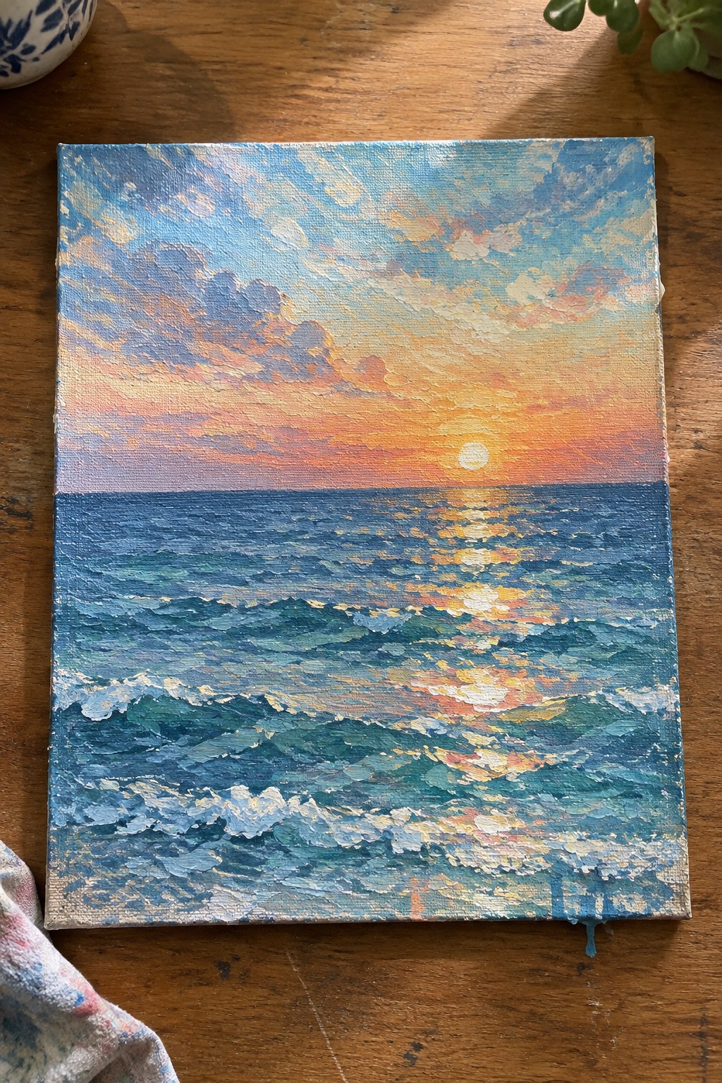 Impressionist canvas painting of ocean sunset with orange sun, pink clouds, and blue waves