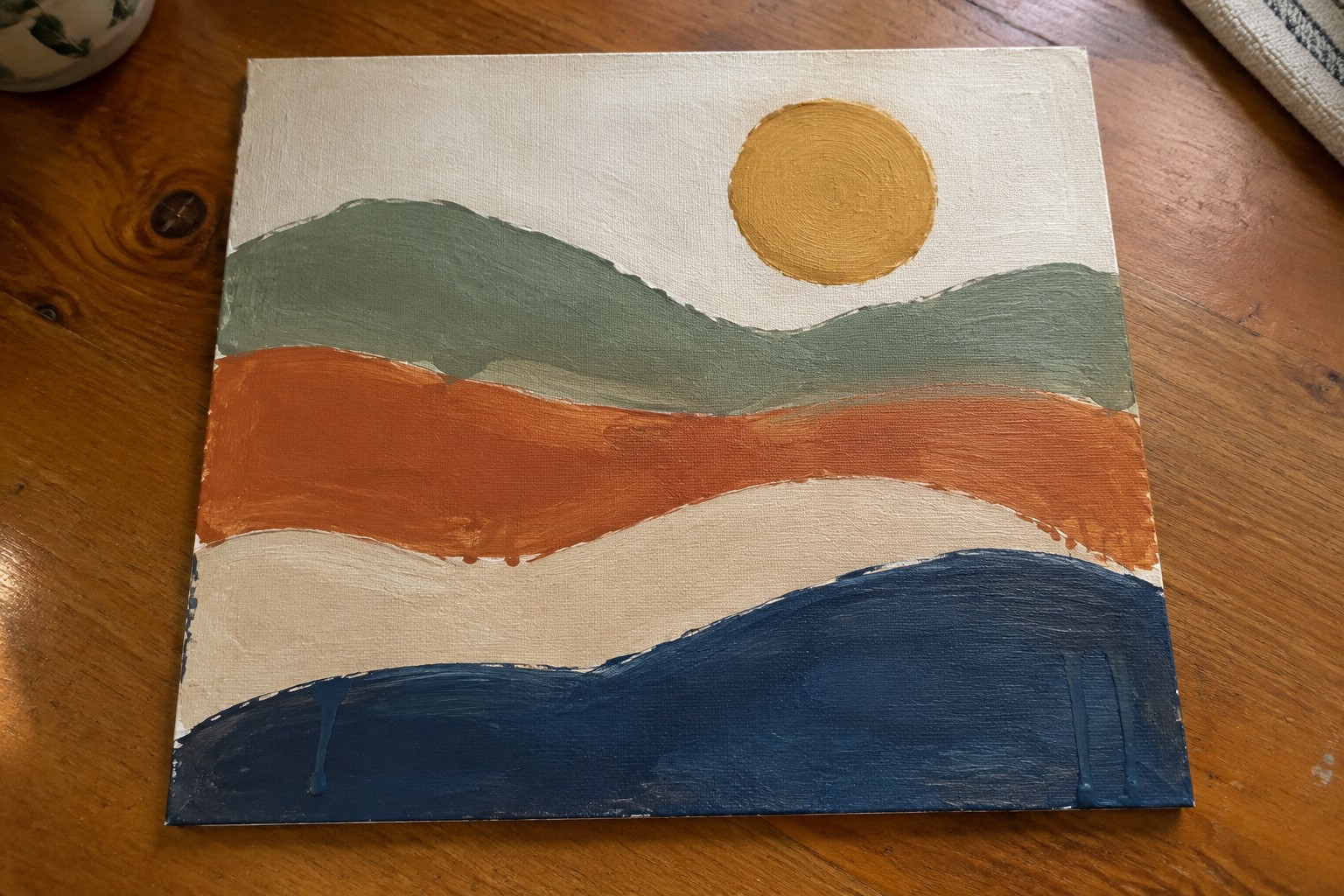 Abstract painting on canvas with wavy green, orange, beige, blue layers and yellow sun
