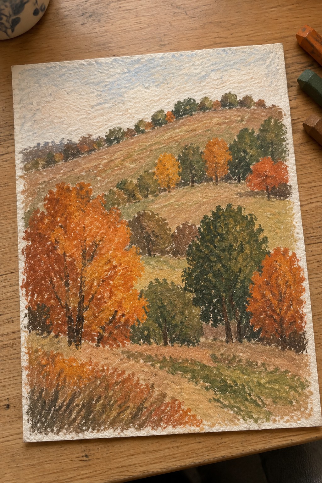 Autumn landscape pastel drawing with orange and red trees on rolling hills