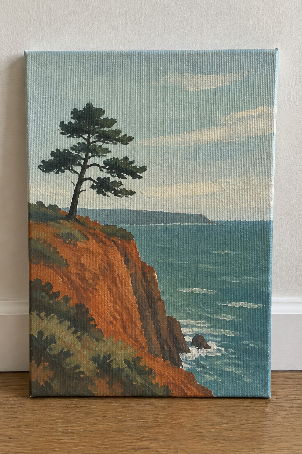 A painting of a single dark green pine tree on a red-orange cliff above a blue ocean with small waves and a distant shoreline.