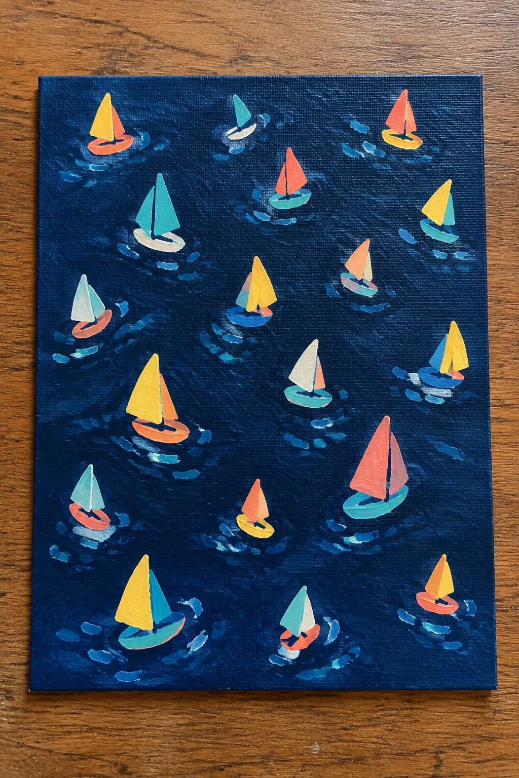 Colorful sailboats with bright sails scattered on dark blue painted waves