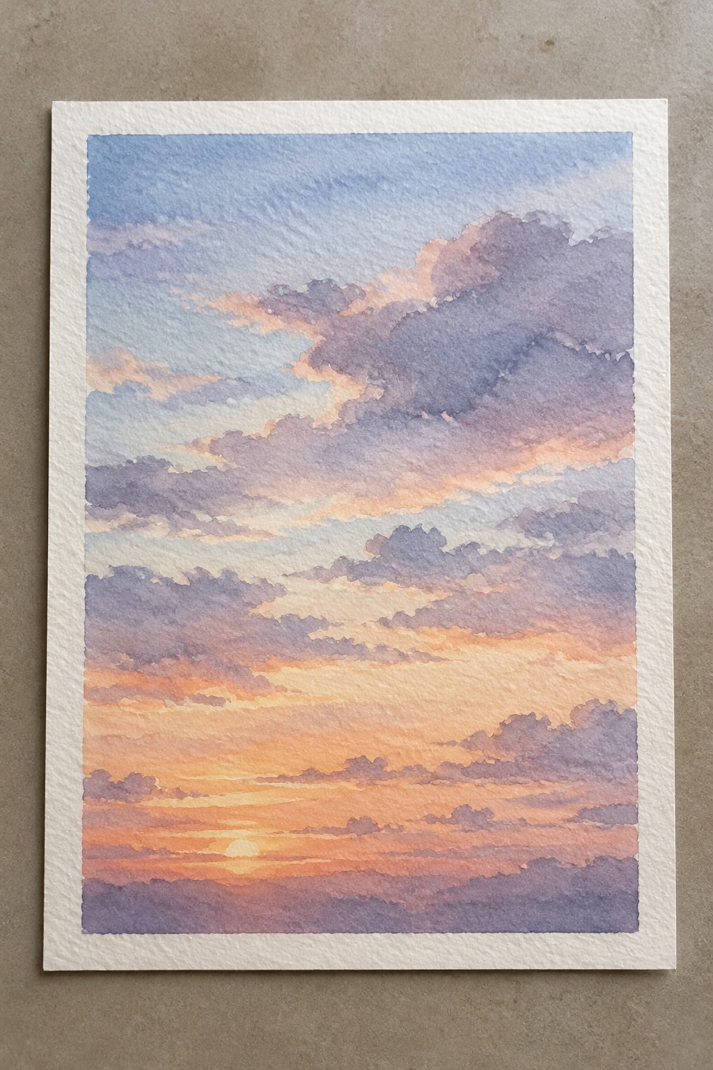 A watercolor painting of a sunset sky with horizontal layers of clouds in blue, purple, orange, and pink tones and the sun visible on the horizon.
