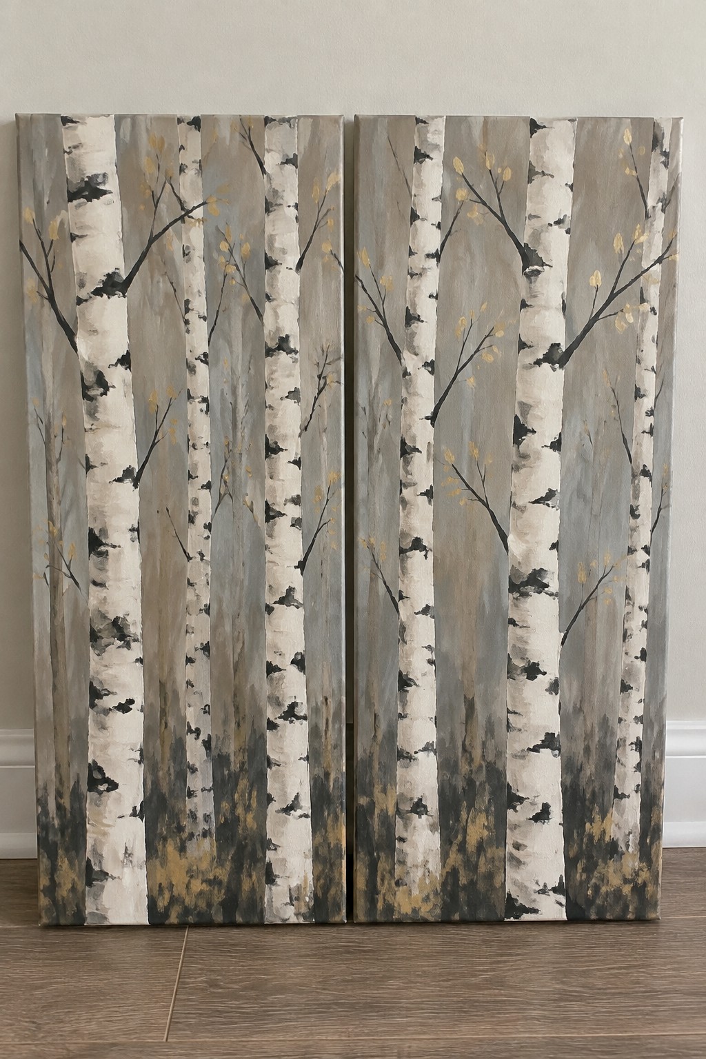 Two side-by-side paintings of birch trees with white bark, black markings, and golden leaves