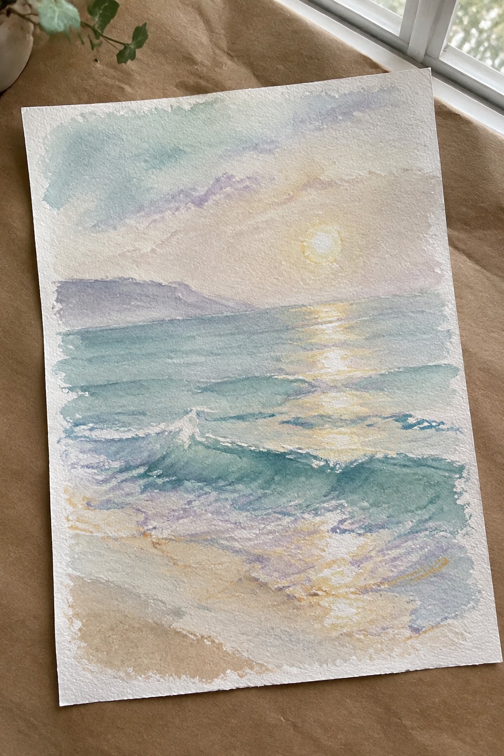 Watercolor seascape of turquoise waves, golden sun reflection, sandy beach and pastel sky.