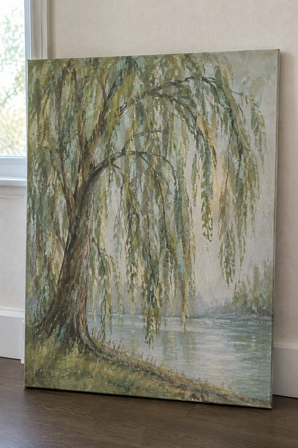 Weeping willow with drooping green branches beside calm misty water on canvas
