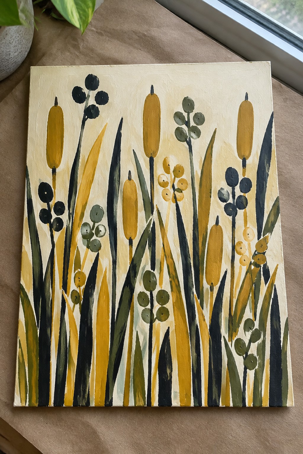 Abstract painting of yellow cattails with green and black reeds on beige canvas
