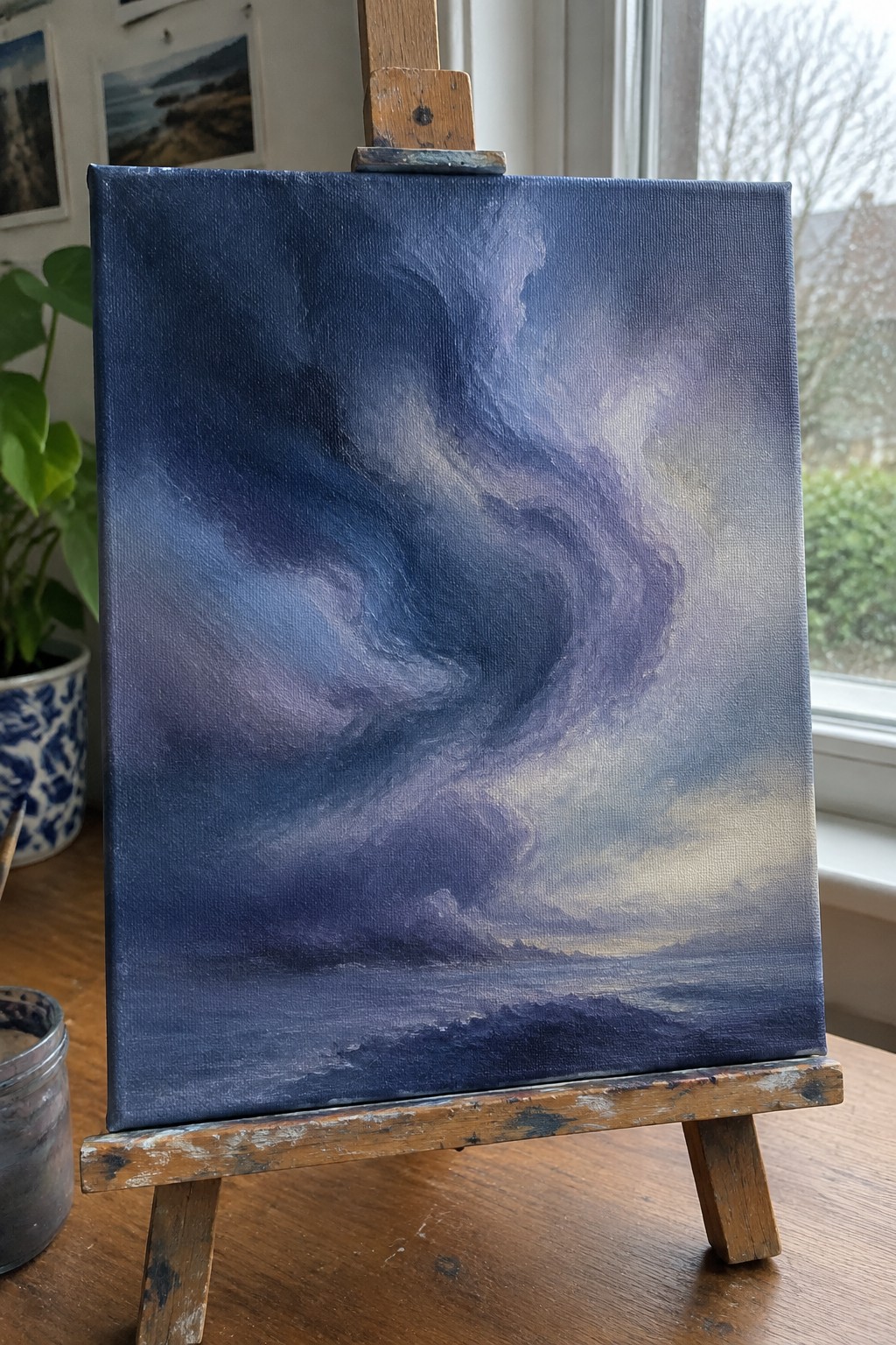Dramatic stormy sky painting with swirling blue and purple clouds on wooden easel